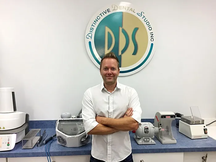 Trevor Hillmann standing in front of a DDS logo